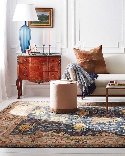 Ottomans can serve as side tables too. An added advantage of a small round ottoman like this one is that it provides complementary curves to a room dominated by straight lines.
